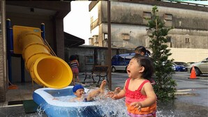 A child playing in a water play area with a slide and an inflatable pool. - Tesla Charging Kimura Elevator B&B (Luodong)