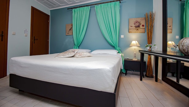 Un dormitorio con cama, mesita de noche, mesa y espejo.