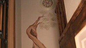Una escalera con un mural de un árbol en la pared.