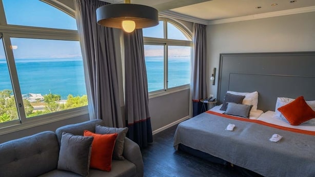 Une chambre d’hôtel avec un lit, un canapé et vue sur la mer.
