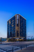 Un hotel moderno con un letrero llamativo que dice "Hotel Lennon" y "Cafe Lennon" en la planta baja.