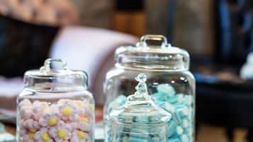 Trois bocaux en verre remplis de bonbons colorés, posés sur une table en bois.