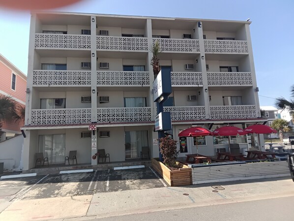 A multi-story hotel with a patterned facade, outdoor seating, and a visible sign for a 15-minute parking limit. - The Atlantic Hotel (Myrtle Beach)