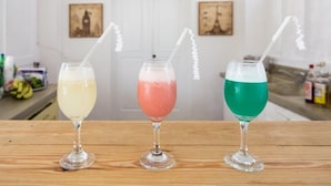 Three drinks in glasses with white straws on a wooden table in a kitchen. - Northway's Hotel Monte Cristo (Cabarete)