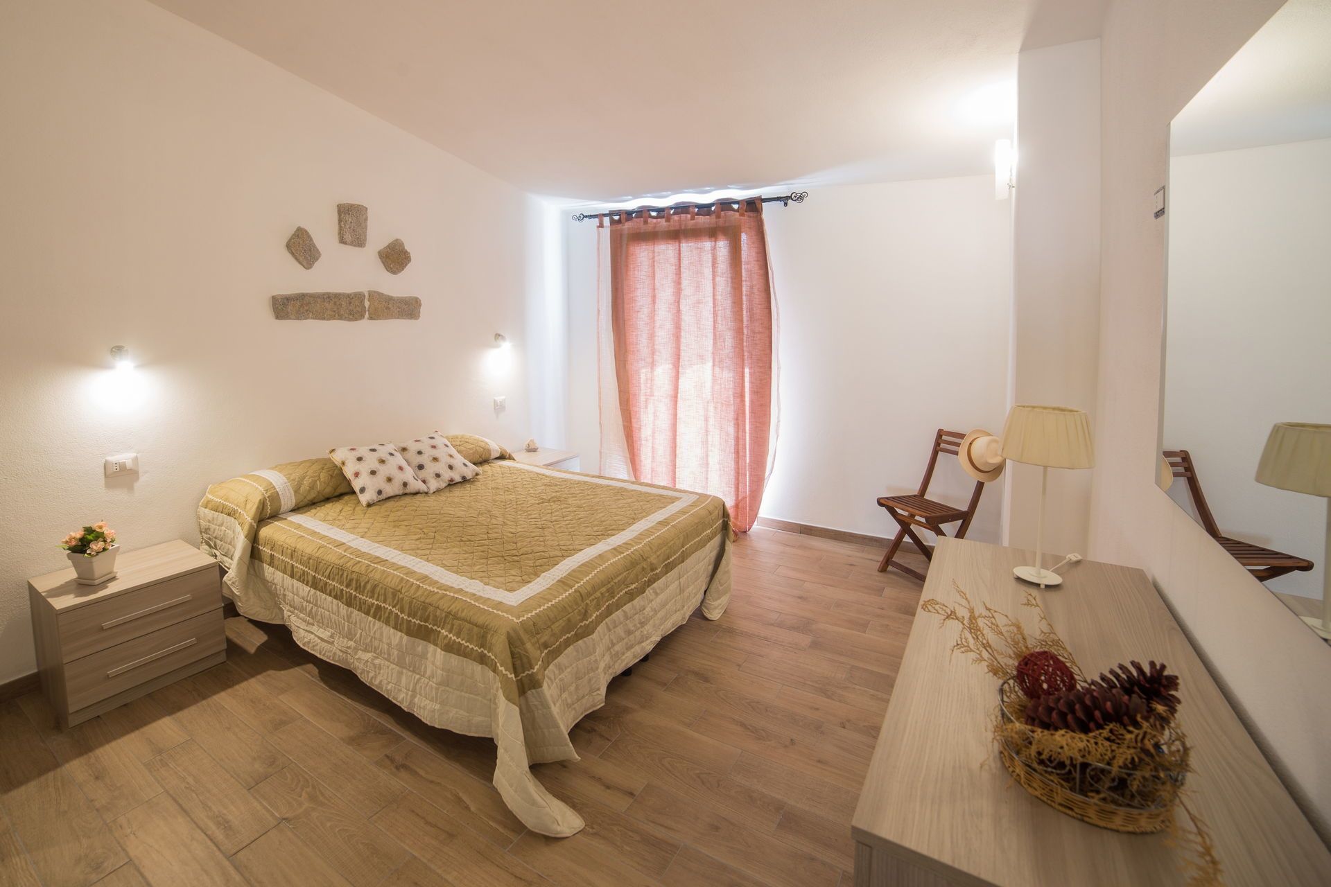 A bedroom with a bed, bedside tables, a chair, a lamp, and a mirror.