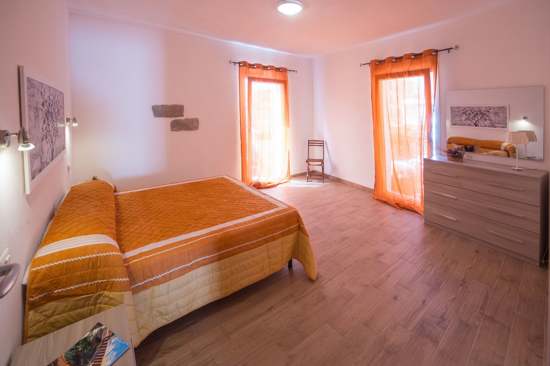 A bedroom with a bed, a dresser, and a chair.