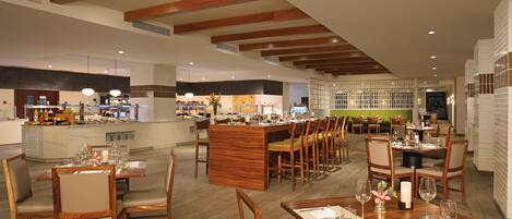 A spacious restaurant with wooden furniture and a central bar area.