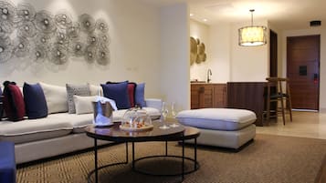 A modern living room with a sofa, a coffee table, and a dining area with a bar.