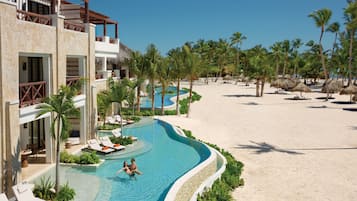Ein Resort mit Schwimmbad, Liegestühlen und Palmen.