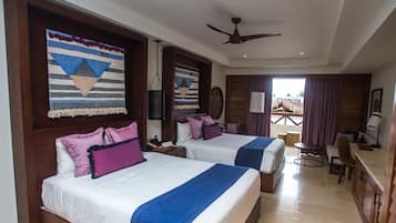 A hotel room with two beds, a desk, and a chair.
