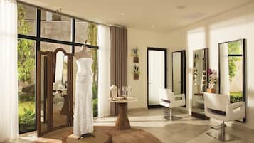 Un salón moderno con ventanas amplias, un maniquí vestido de blanco y dos sillones blancos para peluquería.