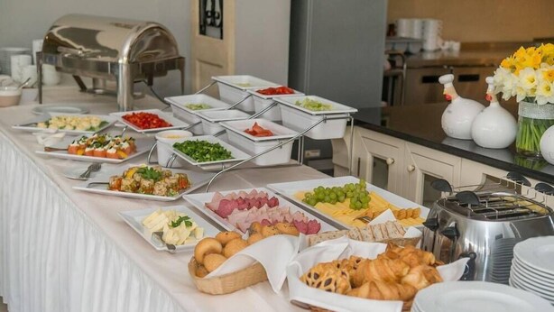 A buffet with various food items and a coffee machine. - Riviera Airport Modlin (OLSZEWNICA NOWA)