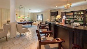 A spacious hotel lobby with a bar area, seating arrangements, and a television screen. - Riviera Airport Modlin (OLSZEWNICA NOWA)