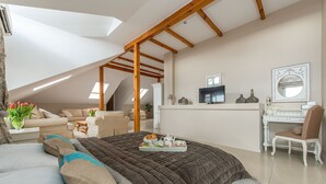A spacious room with a large bed, a desk, and a comfortable seating area. - Riviera Resort Modlin Airport (gmina Wieliszew)