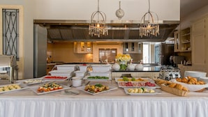 A buffet setup with various food items and a kitchen in the background. - Riviera Resort Modlin Airport (gmina Wieliszew)