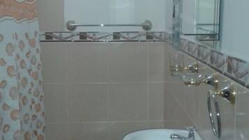 Un baño pequeño con inodoro, lavamanos y espejo.