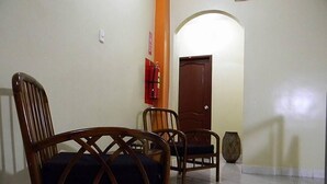 A hallway with two wooden chairs, a fire extinguisher, and a door. - Hotel Rio Guayas (Guayaquil)