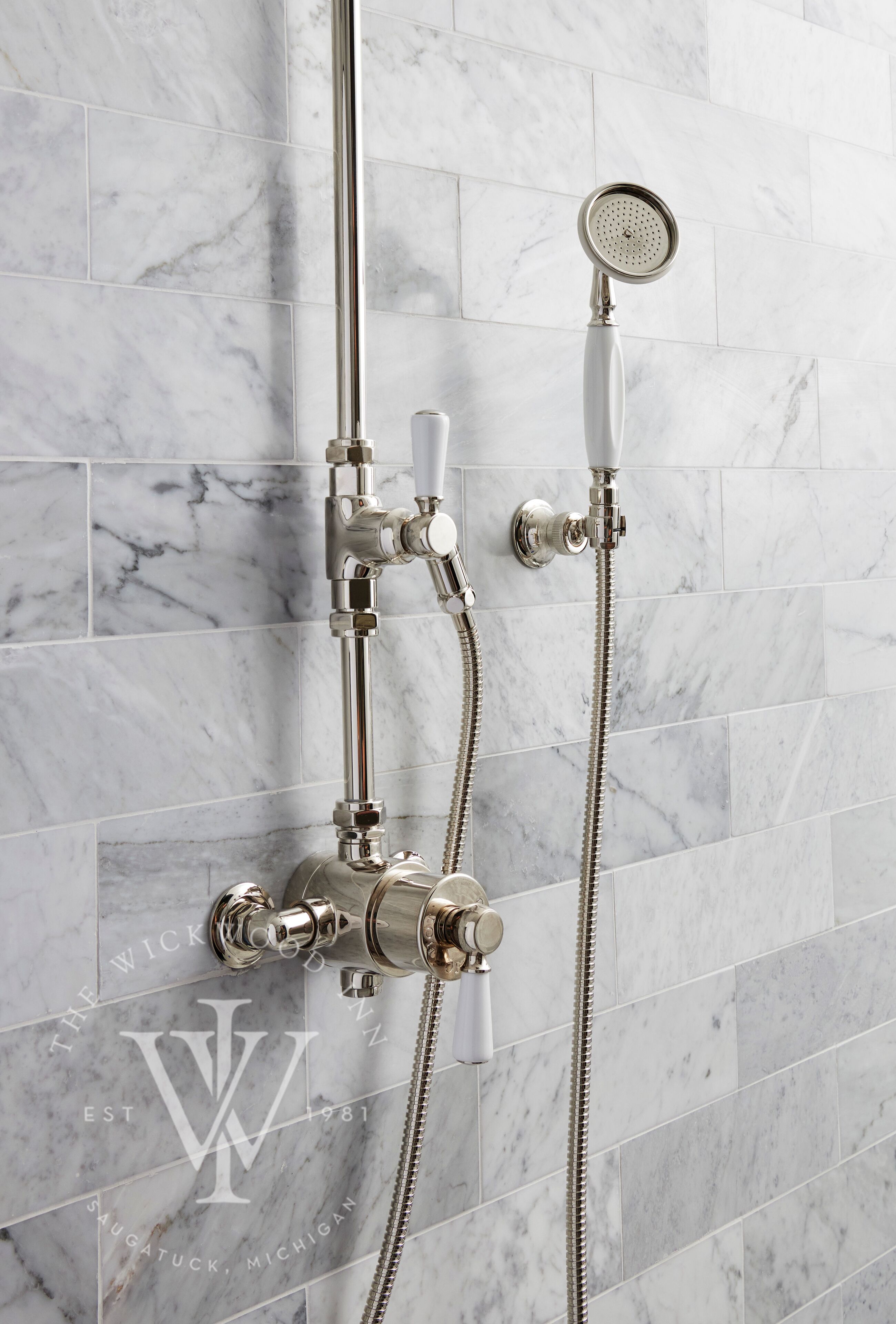 A bathroom with a shower system, including a handheld showerhead and a wall-mounted faucet.