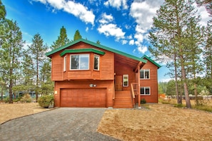 A two-story wooden house with a garage, surrounded by trees. - Keys Lagoon Retreat By RedAwning (South Lake Tahoe)