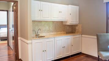 A kitchen with white cabinets, a granite countertop, and a stainless steel sink.