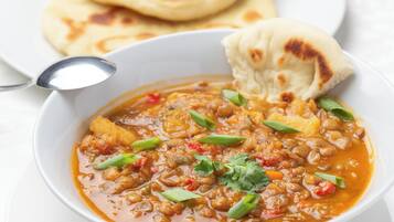 Un tazón de sopa con pan a un lado.