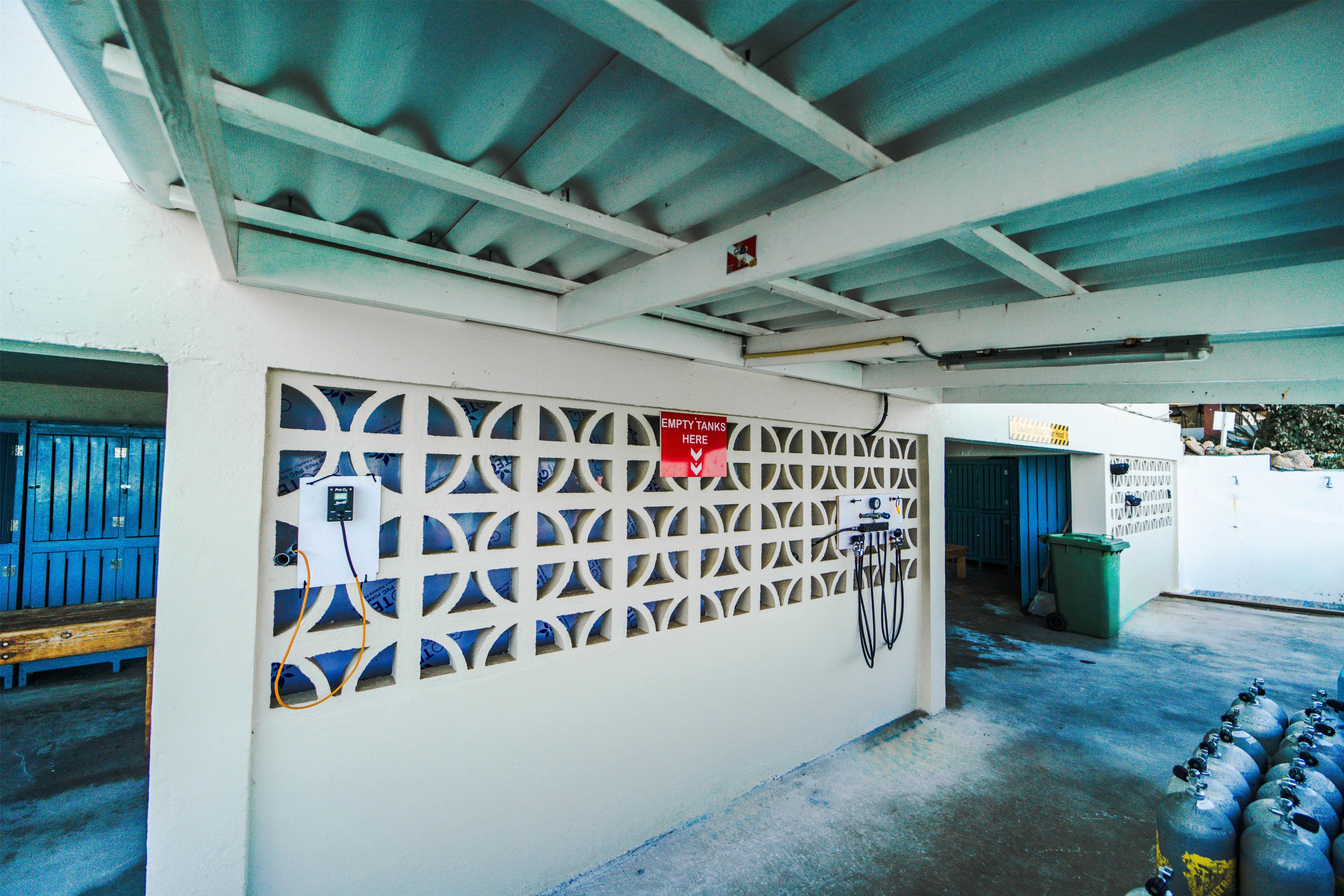 A storage area with blue lockers, a wall-mounted gas meter, and a sign indicating empty tanks.