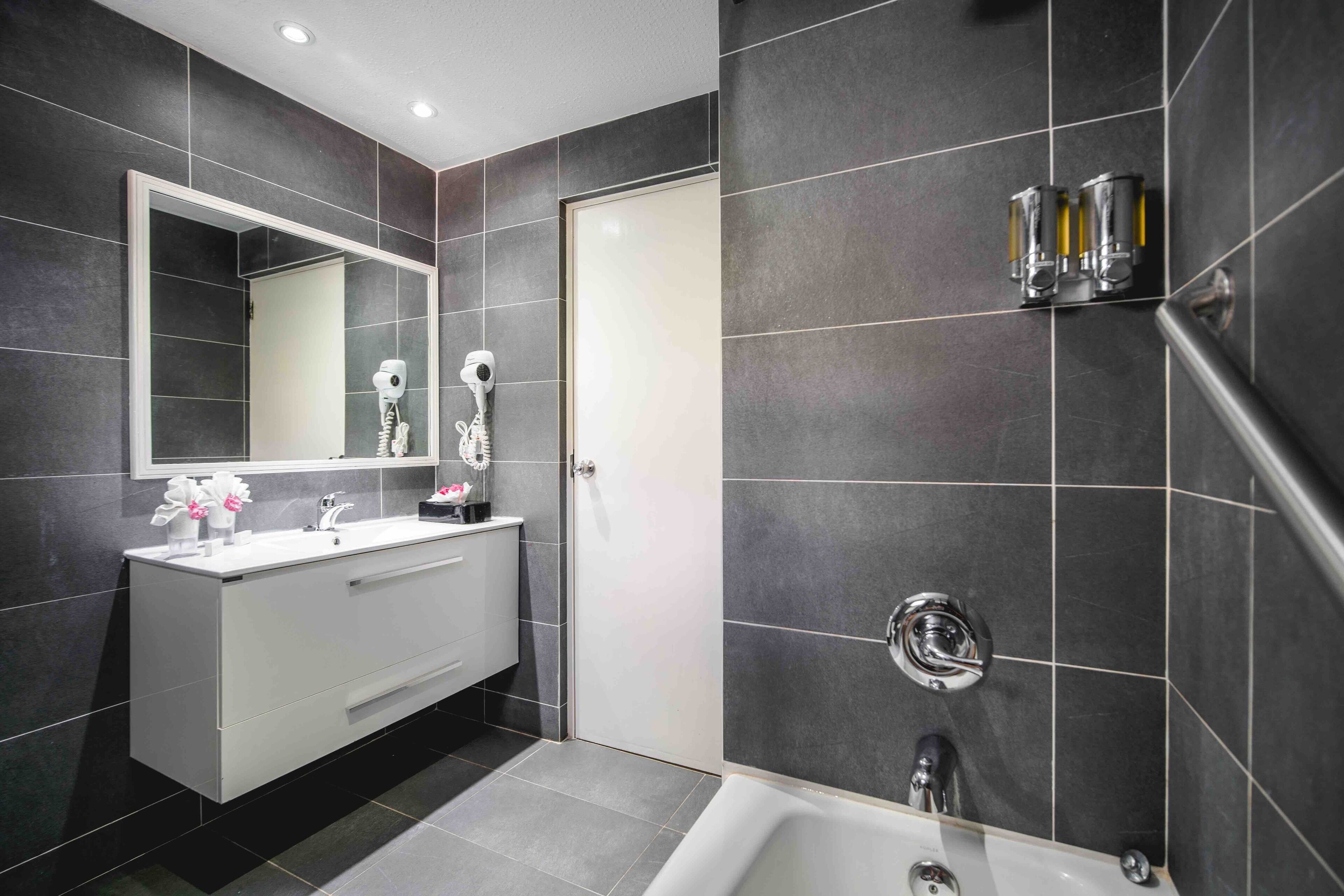 deluxe room | bathroom | shower, hair dryer, towels