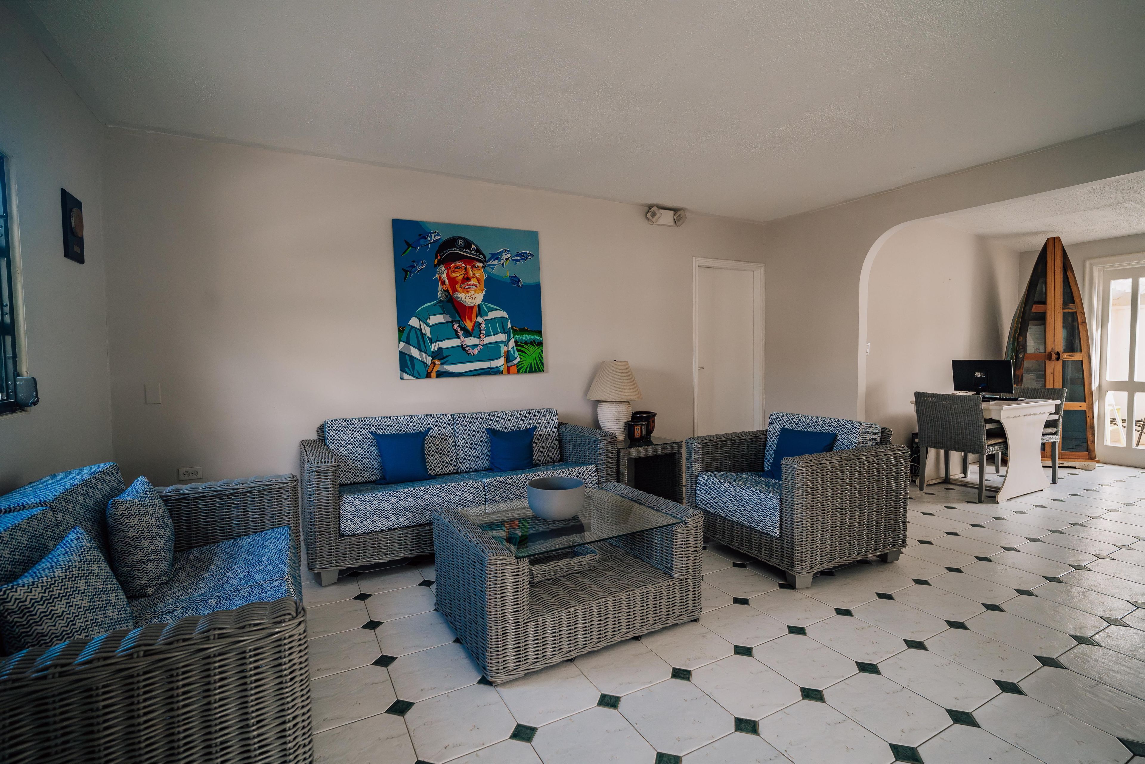 Een woonkamer met een zithoek, een salontafel en een schilderij aan de muur.