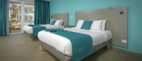 A hotel room with two beds, a sliding glass door to a pool area, and a teal color scheme.