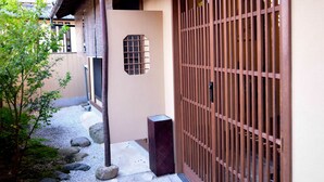 A traditional Japanese building with a wooden exterior, a stone pathway, and a wooden gate.