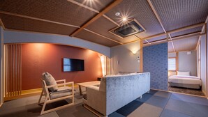 A modern hotel room with a sofa, a small table, a TV, and a bed. - RESI STAY Fuyacho (Kyoto)