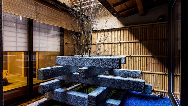 A traditional Japanese garden with stone steps, bamboo walls, and a moss-covered ground. - RESI STAY Fuyacho (Kyoto)