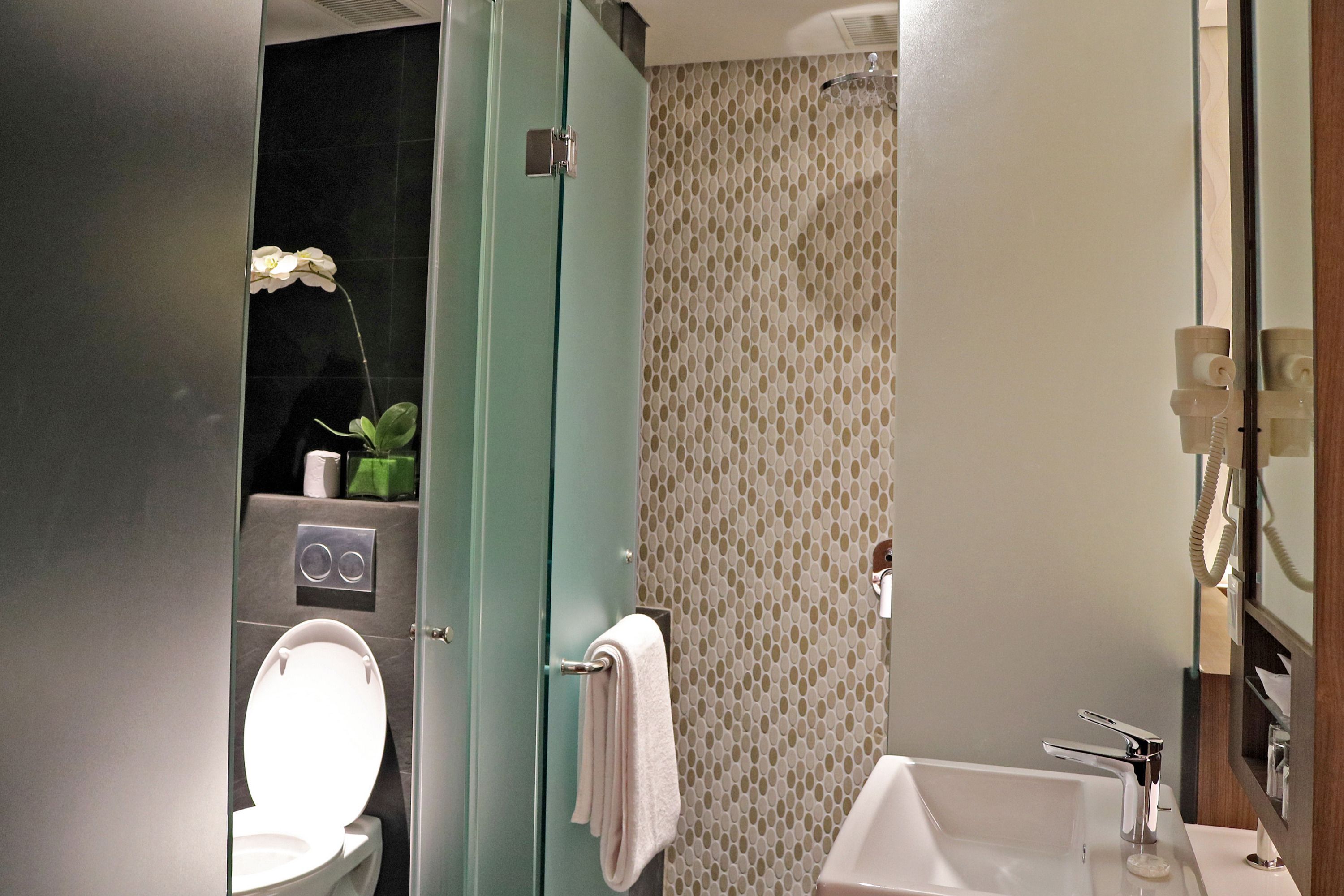 A bathroom with a toilet, a sink, and a shower.
