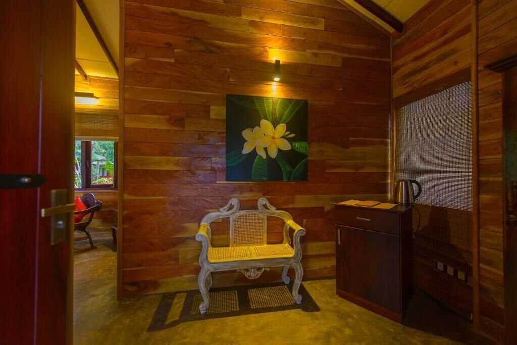A wooden interior with a bench, a painting of a flower, and a coffee machine.