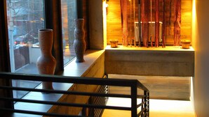 Une chambre avec vue sur la ville, un lit avec une tête de lit et une étagère ornée d’objets décoratifs.