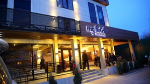Un hôtel doté d’une façade moderne, de grandes fenêtres et d’une entrée accueillante avec des marches et une rampe.
