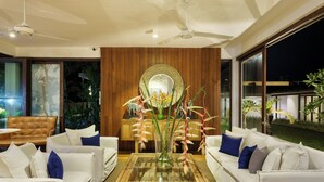 A modern living room with white sofas, a glass coffee table, and a large mirror. - Ubuntu Beach Villas By Reveal (Kamburugamuwa)
