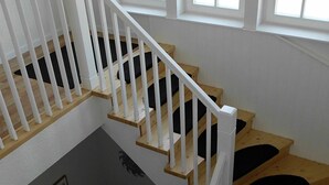 A staircase with white railings and wooden steps. - Villa Regina (Moehnesee)