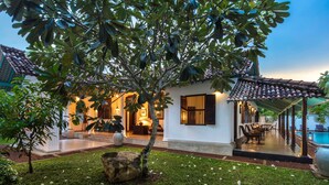 A traditional villa with a swimming pool, outdoor seating, and lush greenery. - Green Casa (Galle)