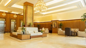 A spacious lobby with a reception desk, seating area, and a large chandelier. - Thousand Nights Hotel Amman (Amman)