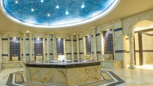 A luxurious lobby with a marble reception desk, ornate columns, and a starry ceiling design. - Thousand Nights Hotel Amman (Amman)