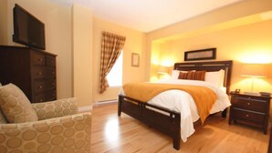 Un dormitorio con cama, cómoda, silla y televisor.