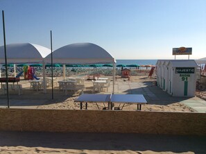 شاطئ خاص، رمال بيضاء، كراسي للتشمس، مظلات الشاطئ