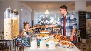A buffet setup with various food items and milk dispensers. - Hotel International (Gabicce Mare)