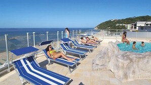 A poolside area with lounge chairs and a pool, overlooking a coastal landscape. - Hotel International (Gabicce Mare)