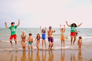 Een groep mensen springt op het strand.