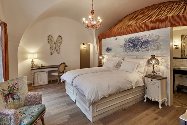 Un dormitorio con una cama grande, un escritorio, una silla y un adorno de pared.