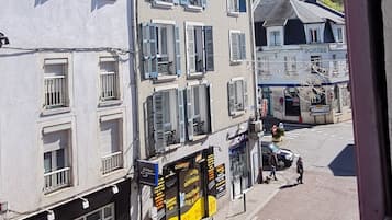 A street view with buildings, a clear sky, and a hilly background.