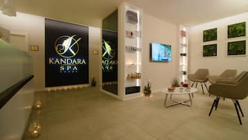 A modern spa interior with a reception desk, seating area, and spa branding.