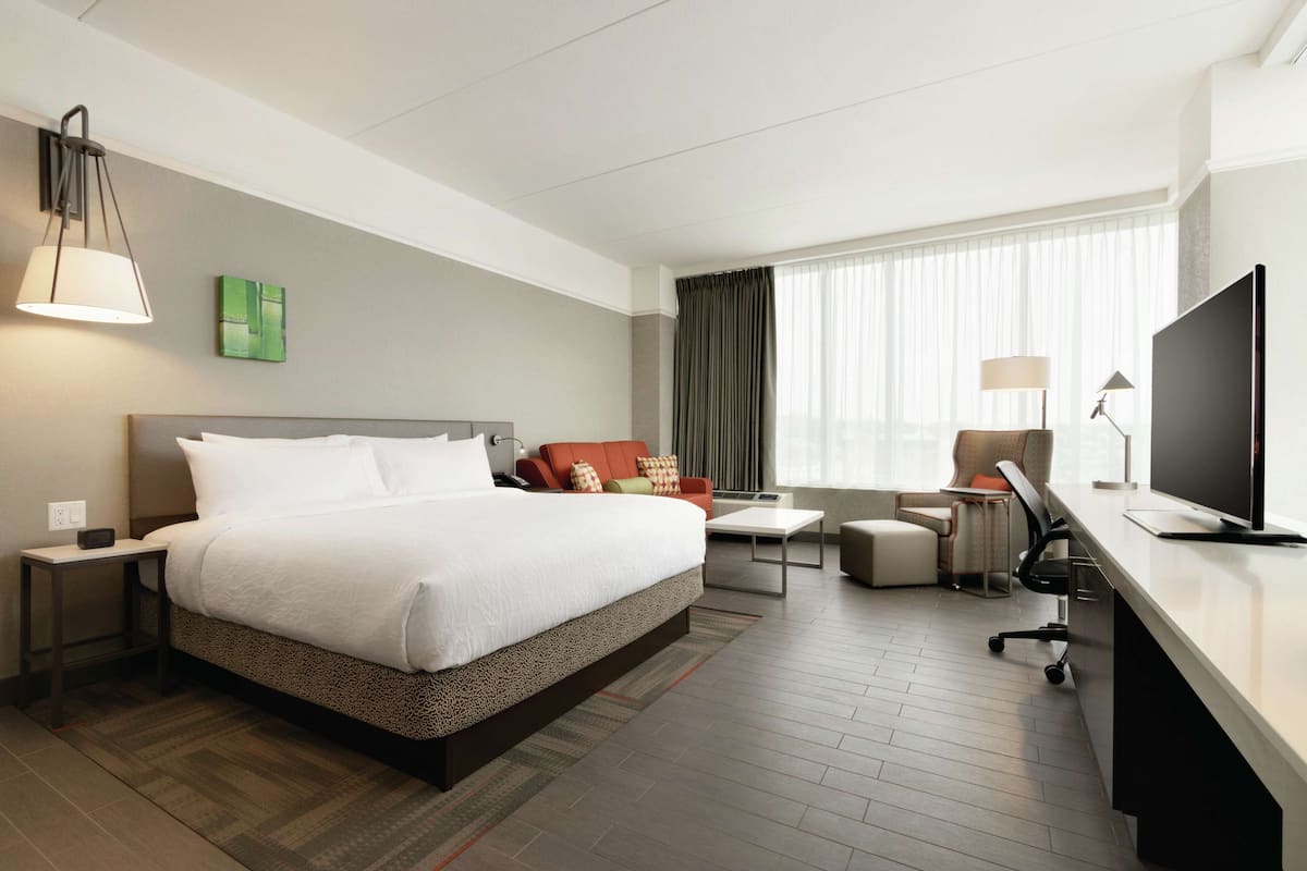 Une chambre d’hôtel moderne équipée d’un grand lit, d’un bureau, d’une chaise et d’un téléviseur.
